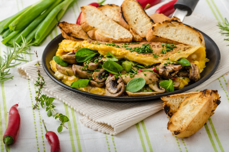 Omelet with mushrooms, lamb's lettuce, herbs and chilli, french toasts